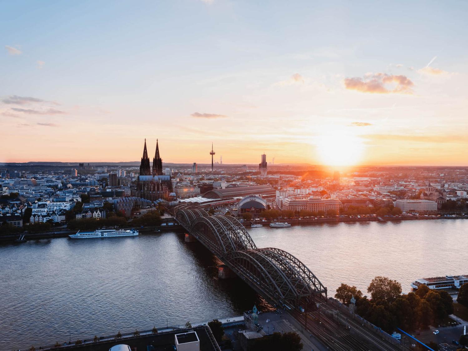 Sonnenuntergang fotografiert von der linken Rheinseite. Man sieht den Kölner Dom und die Hohenzollernbrücke.