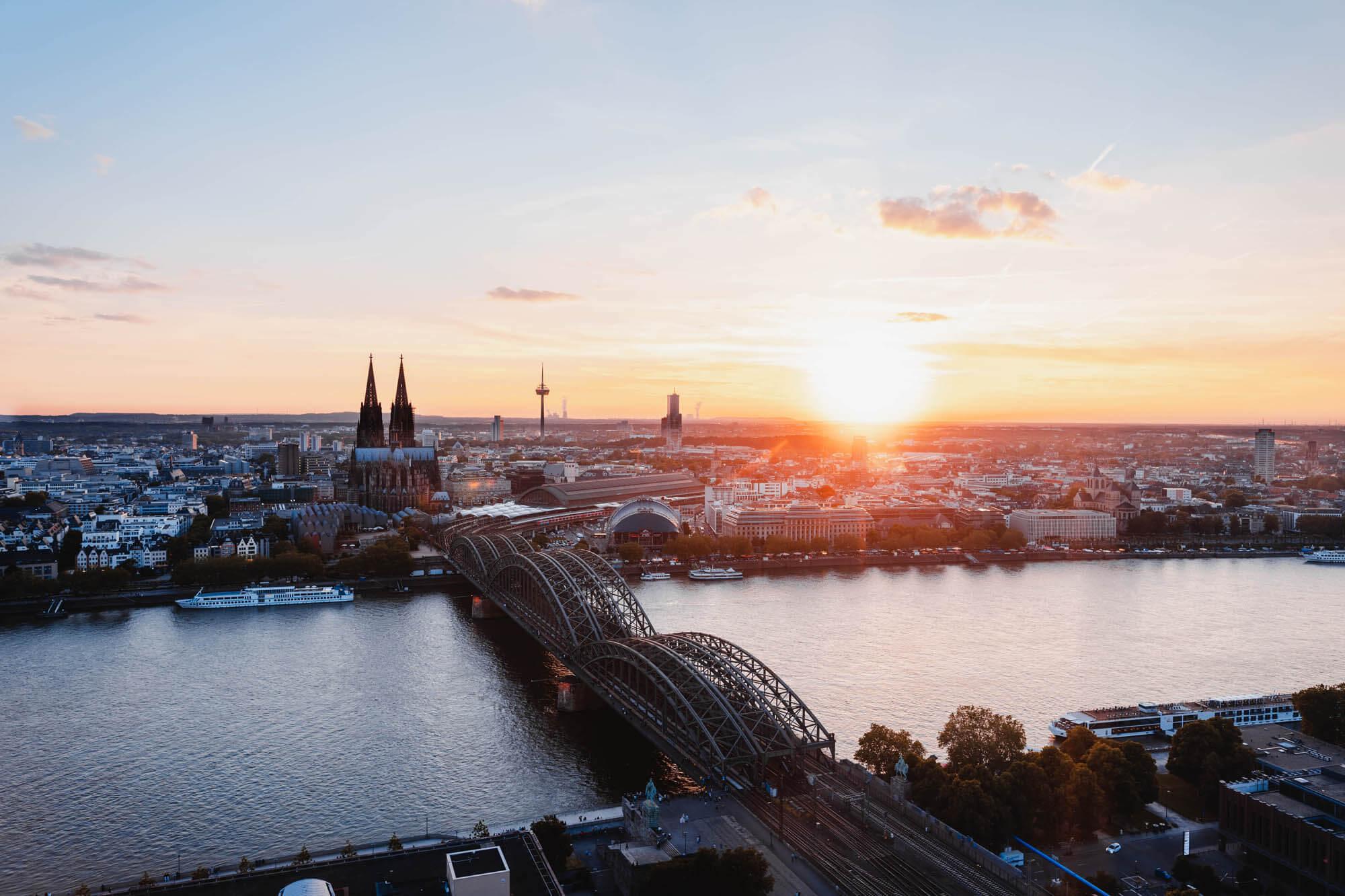 Sonnenuntergang fotografiert von der linken Rheinseite. Man sieht den Kölner Dom und die Hohenzollernbrücke.